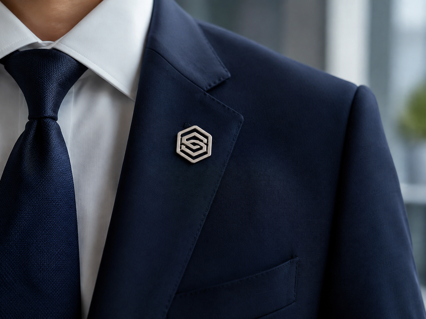Elegant silver corporate logo enamel lapel pin worn on a business suit lapel, used for company branding and employee recognition